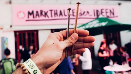 a hand is holding up two nails