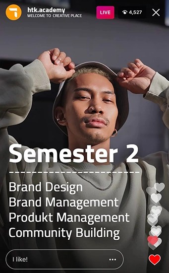 Männlicher Student posiert entspannt in einem Hoodie mit erhobenen Armen vor grauem Hintergrund. Text im Bild: „Semester 2 – Brand Design, Brand Management, Produkt Management, Community Building“.